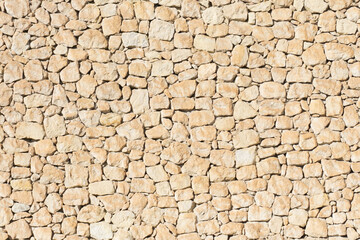 Yelow brick wall. Horizontal decorative uneven blocks background. Urban architecture texture. Solid stone texture. Grunge brickwork structure. Desert look design rock.