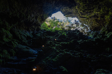 Eploring a volcanic cave in the Volcanic Caves Park at the foot of Villarrica volcano in Pucon,...