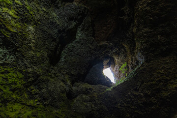 Eploring a volcanic cave in the Volcanic Caves Park at the foot of Villarrica volcano in Pucon,...