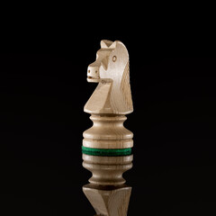 Wooden white chess knight isolated at dark background © Kruwt