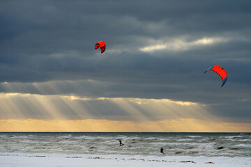 Kite surf in flight in winter. Sunset sky.