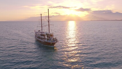 Fototapeta na wymiar Vintage sailing ship sails on the sea at sunset. Seascape. Calm water. Top view. Aerial drone view.