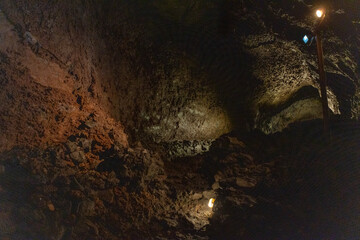Exploring a volcanic cave in the Volcanic Caves Park at the foot of Villarrica volcano in Pucon, Chile 