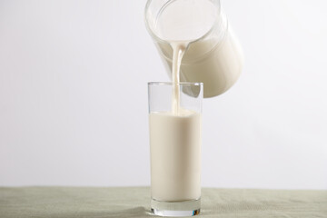 white background of jug and glass with milk