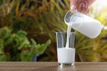 Hand with jug serving milk