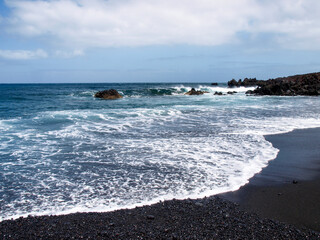 Typical black sand beach of volcanic origin