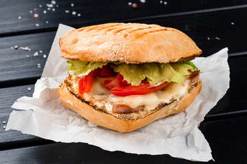 Fresh sandwich with fried bacon, lettuce, cheese and tomatoes.