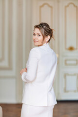 a beautiful and confident woman wearing a white dress and jacket 