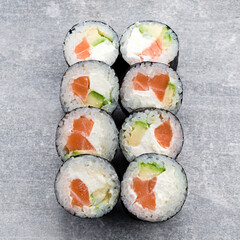 Traditional Japanese cuisine sushi rolls with salmon, avocado and cream cheese.