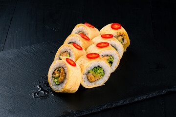 Set of sushi rolls with shrimps, tobiko caviar, lettuce in soy paper.