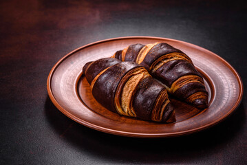 Beautiful tasty fresh crispy croissant on a dark concrete background