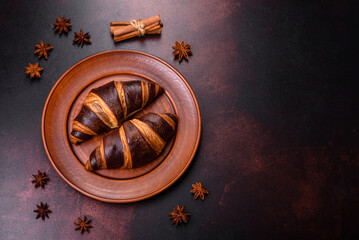 Beautiful tasty fresh crispy croissant on a dark concrete background