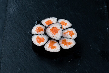 Traditional Japanese kitchen set of sushi rolls with salmon, rice and nori.