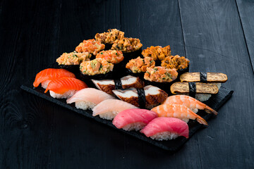 Set of nigiri and gunkans sushi with tuna, salmon, eel, sea bass, shrimp, tamago omelet, avocado and cucumber.
