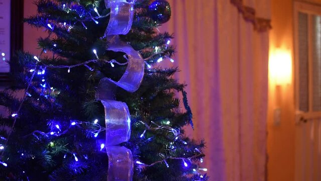 Pino de navidad decorado con luces y esferas dentro de un hogar 