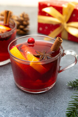 Two cups of christmas mulled wine or gluhwein with spices and orange slices on rustic table top view.
