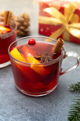 Two cups of christmas mulled wine or gluhwein with spices and orange slices on rustic table top view.