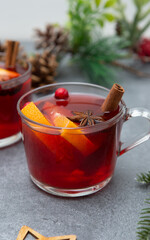 Two cups of christmas mulled wine or gluhwein with spices and orange slices on rustic table top view.