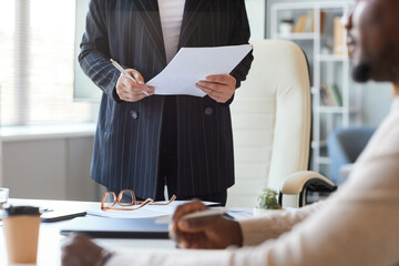 Cropped shot of female boss holding documents during business meeting, copy space