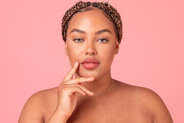 Closeup portrait of beautiful black body positive woman posing on pink studio background, enjoying...