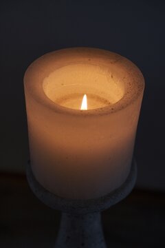 Leuchtende Kerze vor schwarzem Hintergrund