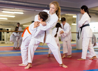 Girl doing throw over her shoulder at a self-defense lesson