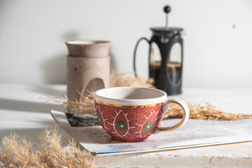 morning coffee with french press and luxury candle ceramic incense burner on a table with magazine