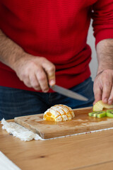 Man in red blouse cooking delicious fruit salad .