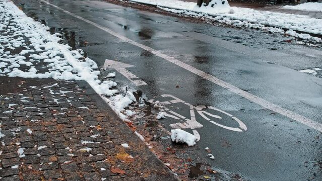 Contraflow Bike Lane Symbol Painted on Asphalt Street Covered in Snow on Winter Day