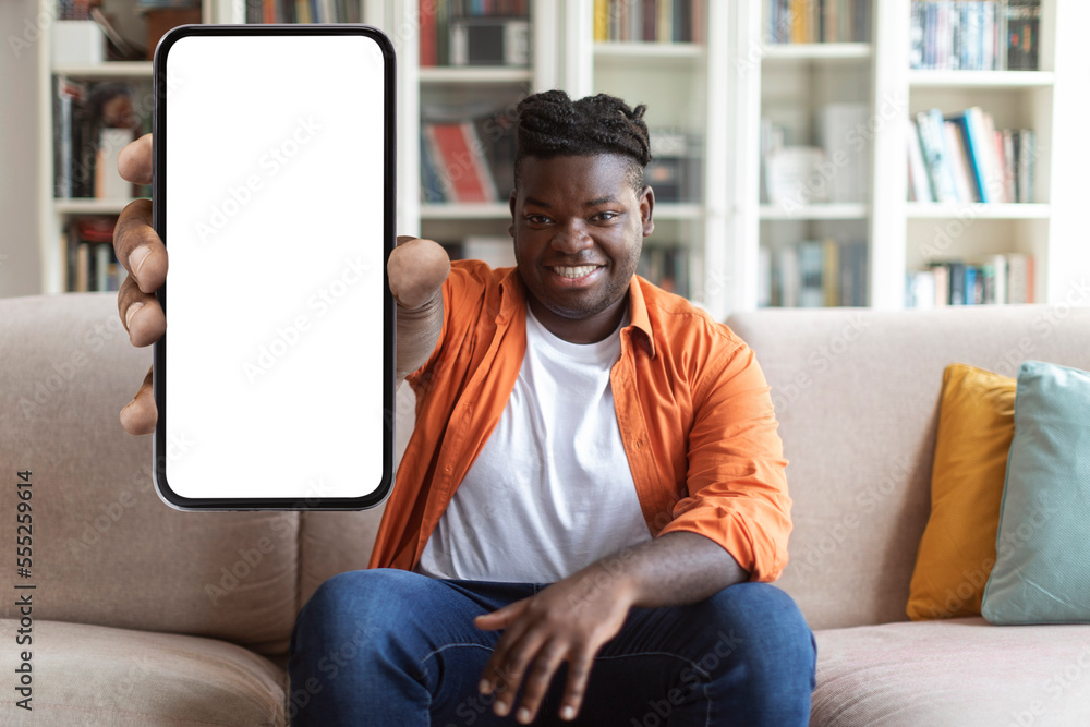 Poster cool chubby black guy showing phone with empty screen