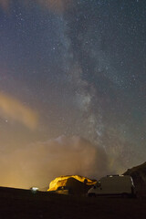 Milky Way in the night sky over camper van in the Pyrenees mountains, Col du Pourtalet, Nouvelle-Aquitaine, France