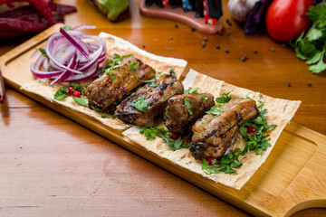 skewers of pork ribs on old wooden table