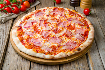 Italian meat pizza with cheese and tomato sauce on wooden table close up - 555260497