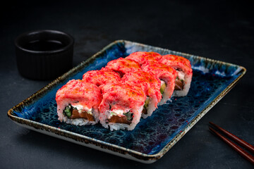 Set of sushi rolls with tuna tartare, salmon, cream cheese, avocado, cucumber, red flying fish caviar and soy sauce.
