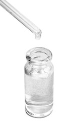 A drop falls from a pipette in cosmetic or medical glass bottle