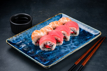 Set of Japanese sushi rolls with tuna, shrimps, cream cheese, avocado, flying fish caviar and marinated chuka seaweed.