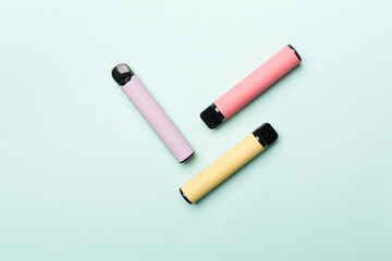 Disposable electronic cigarettes on color background, top view