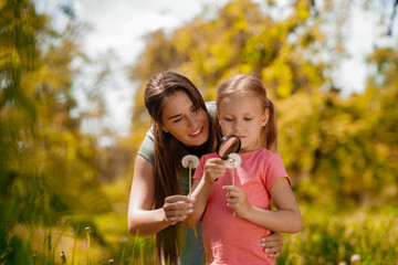 Mom and daughter feeling peaceful in the park while investigating plants