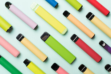 Disposable electronic cigarettes on color background, top view