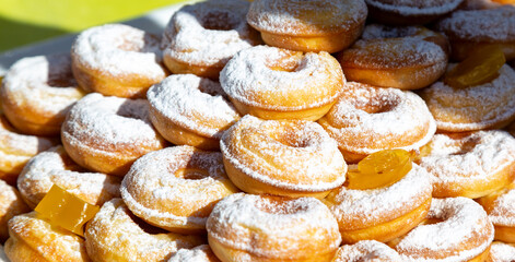 A pile of donuts with powdered sugar