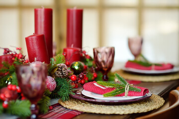 Christmas table set with wreath and red candles. Eve Xmas.