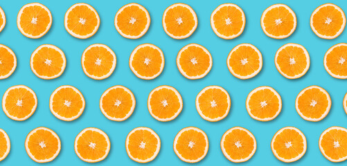 Fruit pattern of orange slices on blue background. Top view.