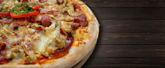 Pizza with sausage, mushrooms and tomatoes, on a wooden board. Banner