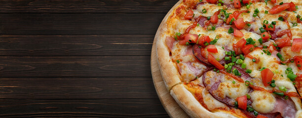 Pizza with meat, sausage, tomatoes and cheese, on a wooden board. Banner
