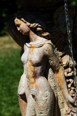 Tight Detail Shot Of Female Figure On Water Fountain With Grass