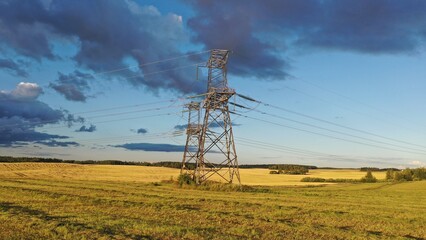 Kyiv Region, Ukraine - 25.08.2022: Power line near Kyiv. Towers and wires of power lines. Power line in the field of colors of the flag of Ukraine