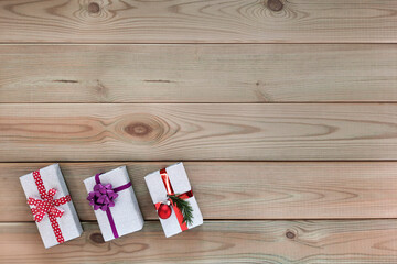 Festive gift wrapping. Flatlay. Mockup for advertisement for christmas and new year with place for text. Gift boxes decorated with shiny paper and Christmas decor on wooden planks. Top view. Copyspace