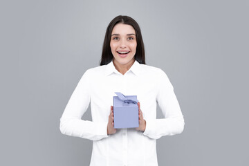 Fototapeta premium Portrait of a happy smiling girl holding present box and isolated over gray background.