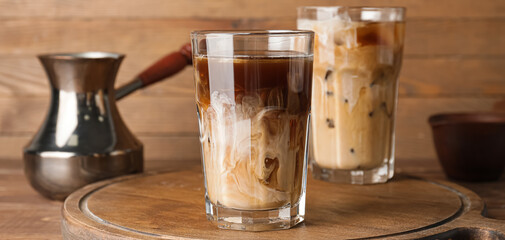 Glass of cold brew coffee with milk on wooden background