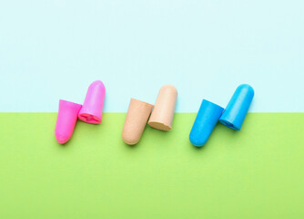 Different ear plugs on color background